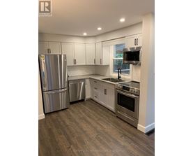 A kitchen with a stainless steel refrigerator, dishwasher, and oven.