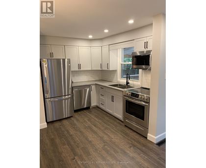 A kitchen with a stainless steel refrigerator, dishwasher, and oven.