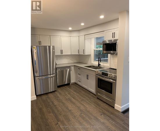 A kitchen with a stainless steel refrigerator, dishwasher, and oven.