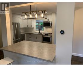 A modern kitchen with a stainless steel refrigerator, microwave, and oven.