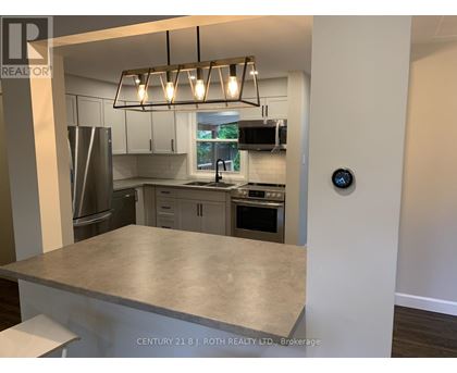 A modern kitchen with a stainless steel refrigerator, microwave, and oven.