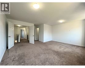 A spacious room with carpeted floor and white walls.
