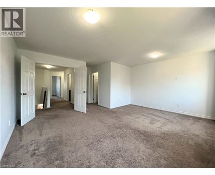 A spacious room with carpeted floor and white walls.