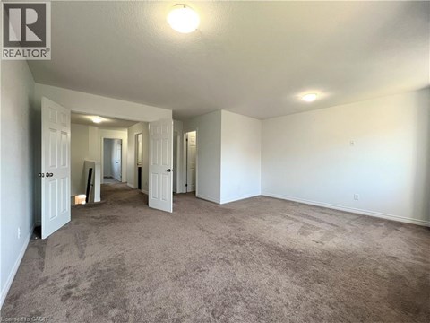 A spacious room with carpeted floor and white walls.