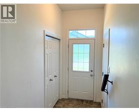 A white door is in a hallway with a window above it.