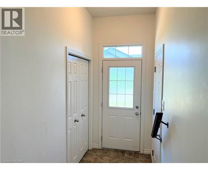 A white door is in a hallway with a window above it.