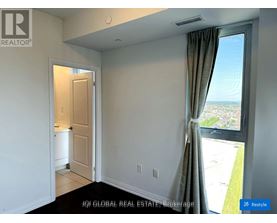 A room with a window overlooking a parking lot.