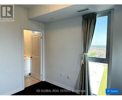 A room with a window overlooking a parking lot.