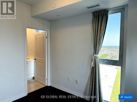 A room with a window overlooking a parking lot.