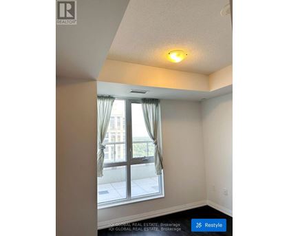 A room with a window and a view of a building outside.