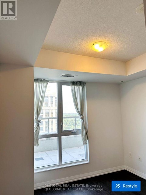 A room with a window and a view of a building outside.