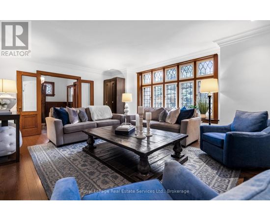 A living room with a large table and blue chairs.