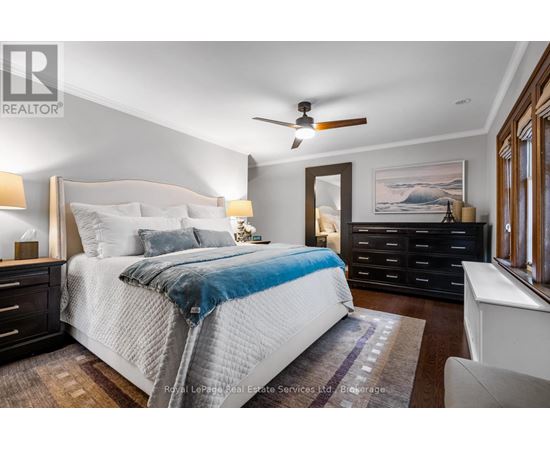 A bedroom with a large bed and a ceiling fan.