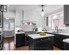 A modern kitchen with black cabinets and white countertops.