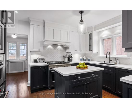 A modern kitchen with black cabinets and white countertops.