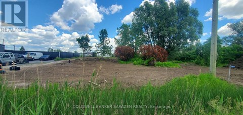 A field with a few trees and a sign that says "REALTOR".