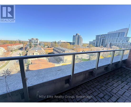 A view from a balcony overlooking a cityscape with buildings and a clear sky.