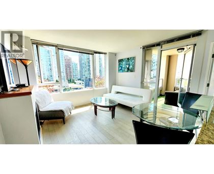A living room with a glass table and a white couch.