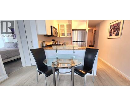 A modern kitchen with a glass table and chairs.