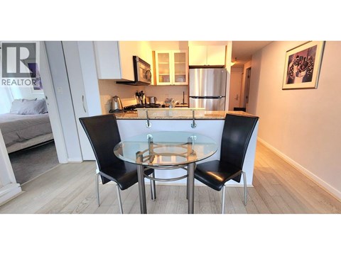 A modern kitchen with a glass table and chairs.