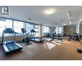 A gym with treadmills, exercise bikes, and weights is shown.