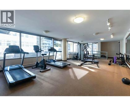 A gym with treadmills, exercise bikes, and weights is shown.