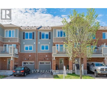 A real estate brokerage photo of a multi-story residential building with cars parked in front.