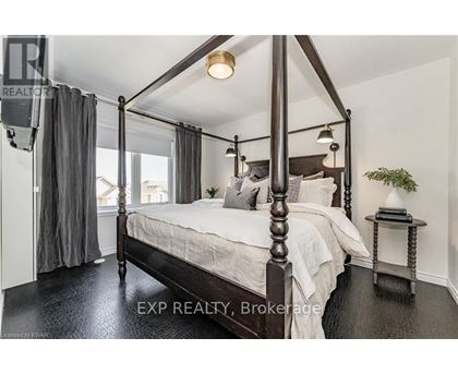 A bedroom with a four poster bed and a small table with a plant on it.