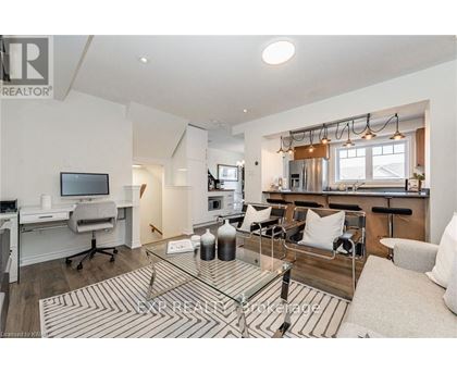 A well-lit living room with a glass coffee table and a television.