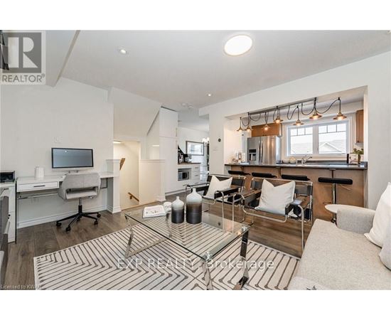 A well-lit living room with a glass coffee table and a television.