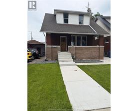 A house with a white door and a brown brick wall.