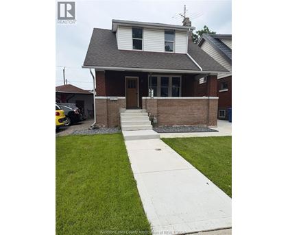 A house with a white door and a brown brick wall.