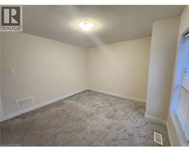 A room with a carpeted floor and a window on the right side.