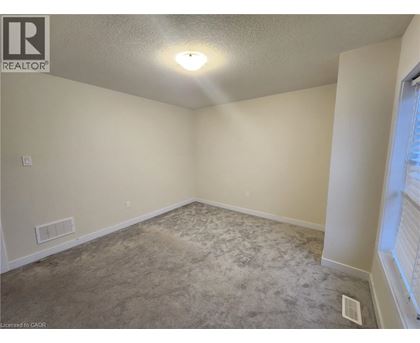 A room with a carpeted floor and a window on the right side.