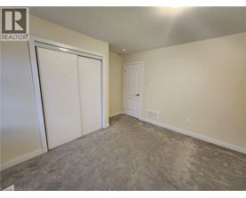 A room with a carpeted floor and two doors.
