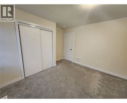 A room with a carpeted floor and two doors.