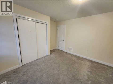 A room with a carpeted floor and two doors.
