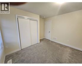 A room with a carpeted floor and two white doors.