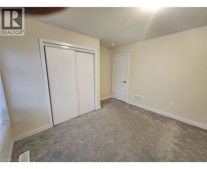A room with a carpeted floor and two white doors.