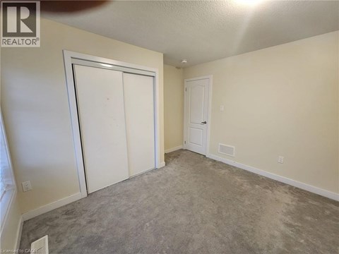 A room with a carpeted floor and two white doors.