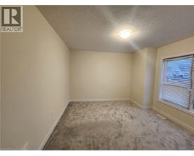 A room with a carpeted floor and a window with blinds.
