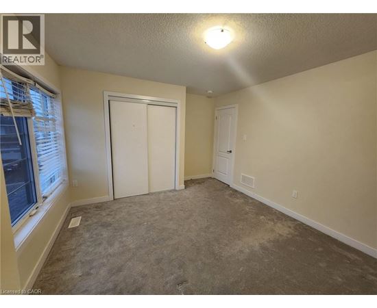 A room with a carpeted floor and a white door.
