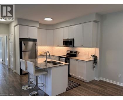A kitchen with white cabinets and a granite countertop.