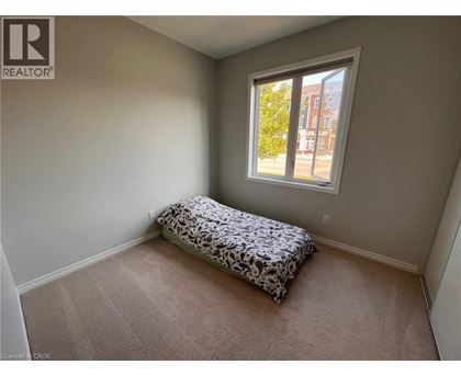 A bedroom with a bed and a window overlooking a street.