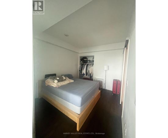 A bedroom with a bed, a wardrobe, and a suitcase.