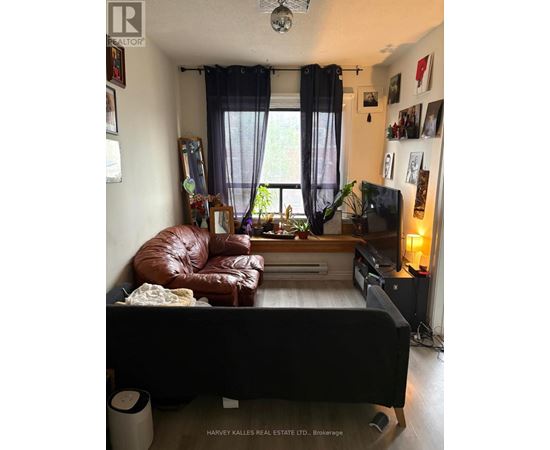 A living room with a brown leather couch and a flat screen TV.