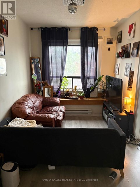 A living room with a brown leather couch and a flat screen TV.
