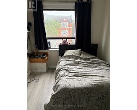 A bedroom with a large bed and a window overlooking a red building.