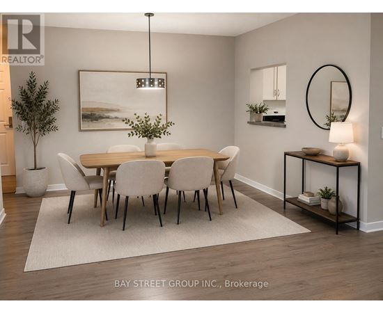 A dining room with a table set for six with white chairs.