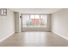 A spacious room with a view of a red building across the street.